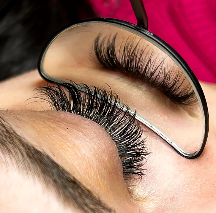 Kontrolle eines frisch gesetzten Wimpernsets mit dem Spiegel